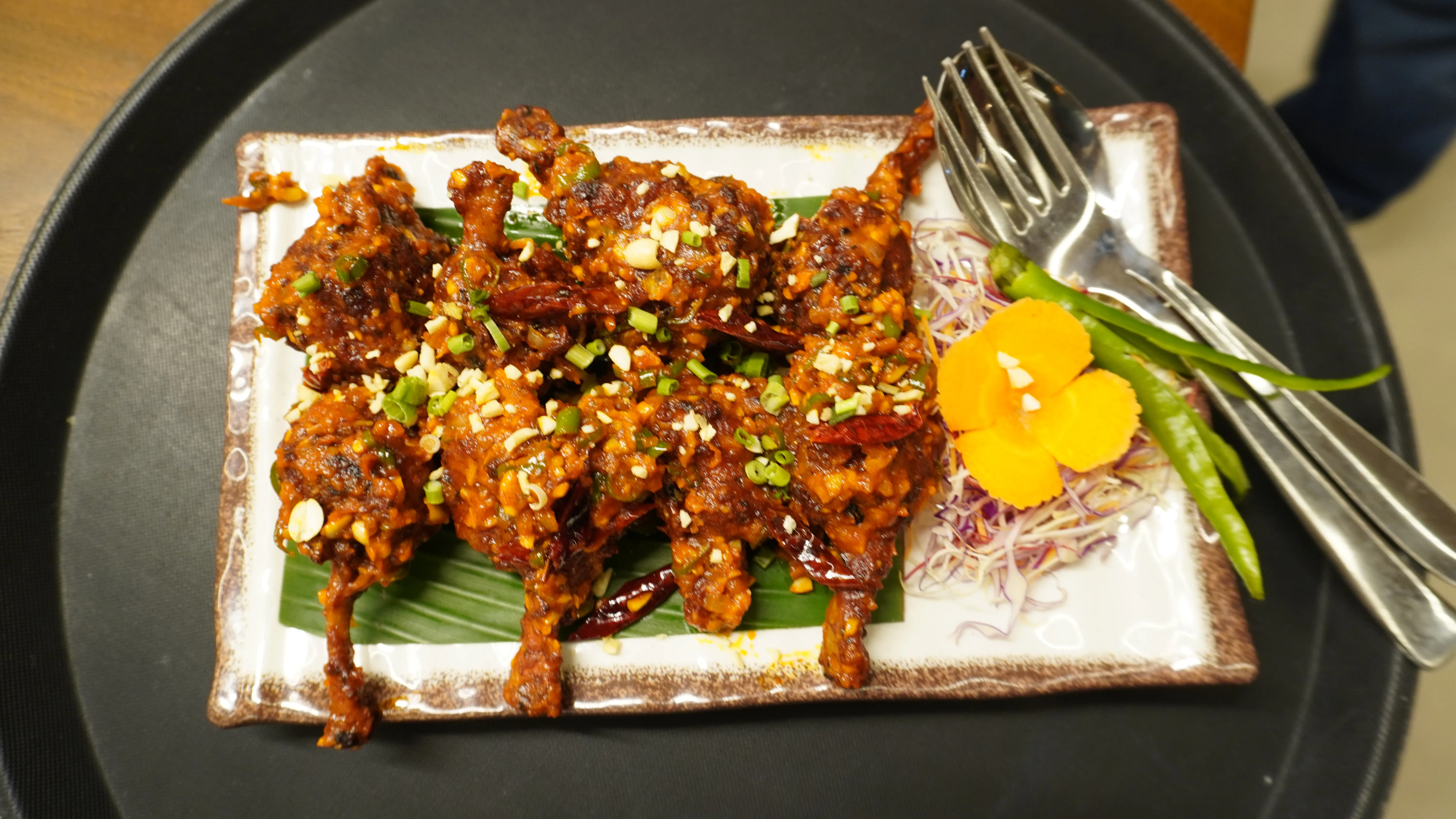 Horizontal image of a serene lake reflecting snow-capped mountains and pine trees