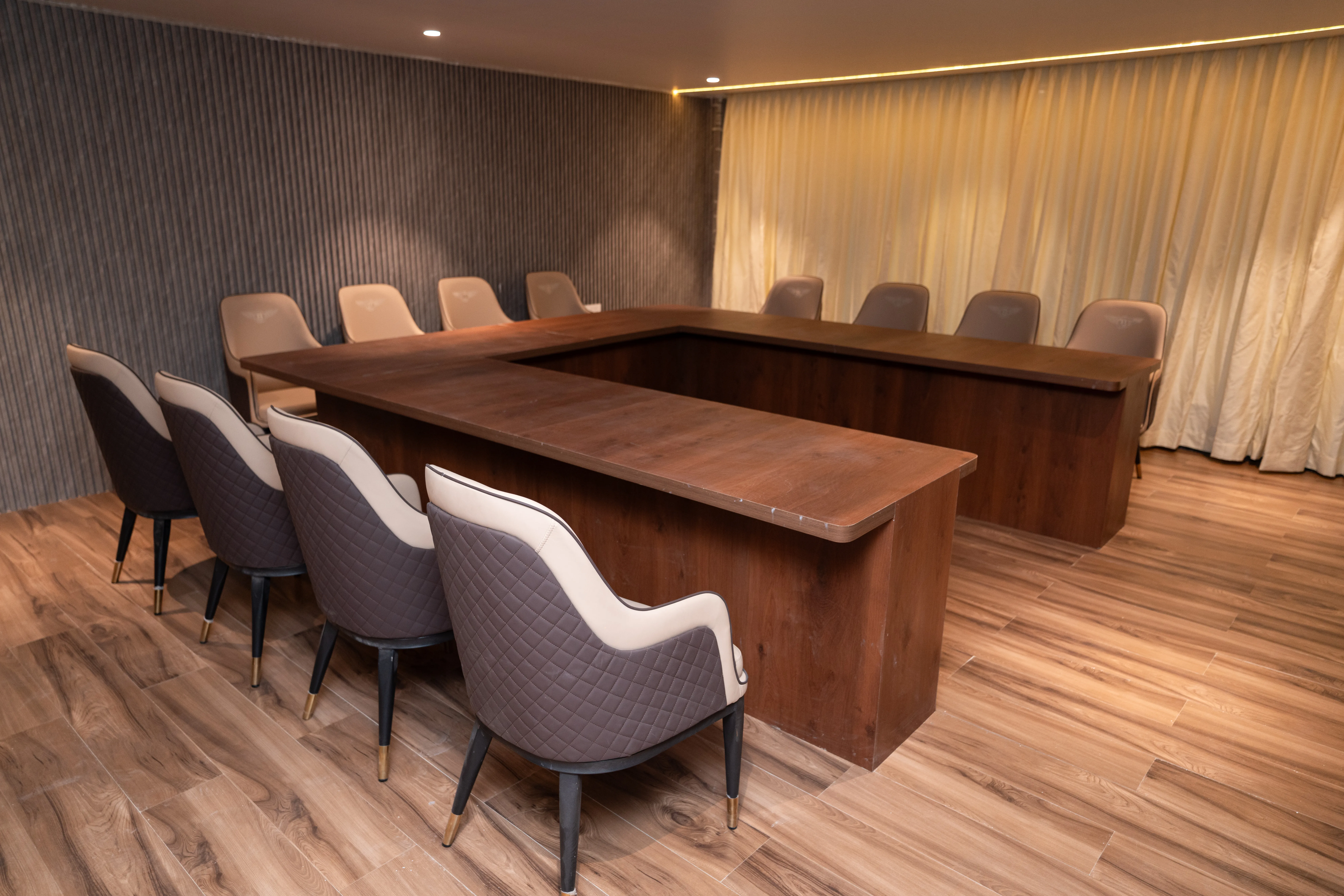 Professional business meeting setup with boardroom seating, projector, and notepads