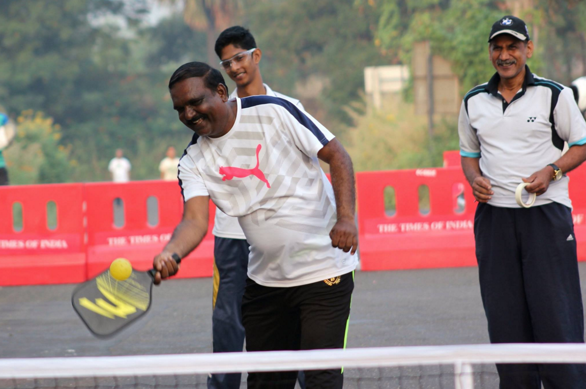Two players competing in an intense pickleball match on an outdoor court with clear blue sky